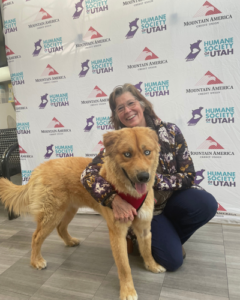 A middle aged woman poses with newly adopted dog during Fall in Love Adoption Event.