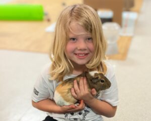 kid holding guinea pig