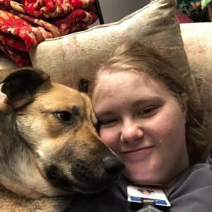 Maverick cuddles with his new owner on the couch.
