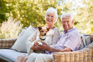 senior couple laughing with small dog
