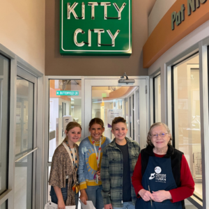 Olivia a 7th grader stands in front of Kitty City with friends and HSU volunteer, Mary.